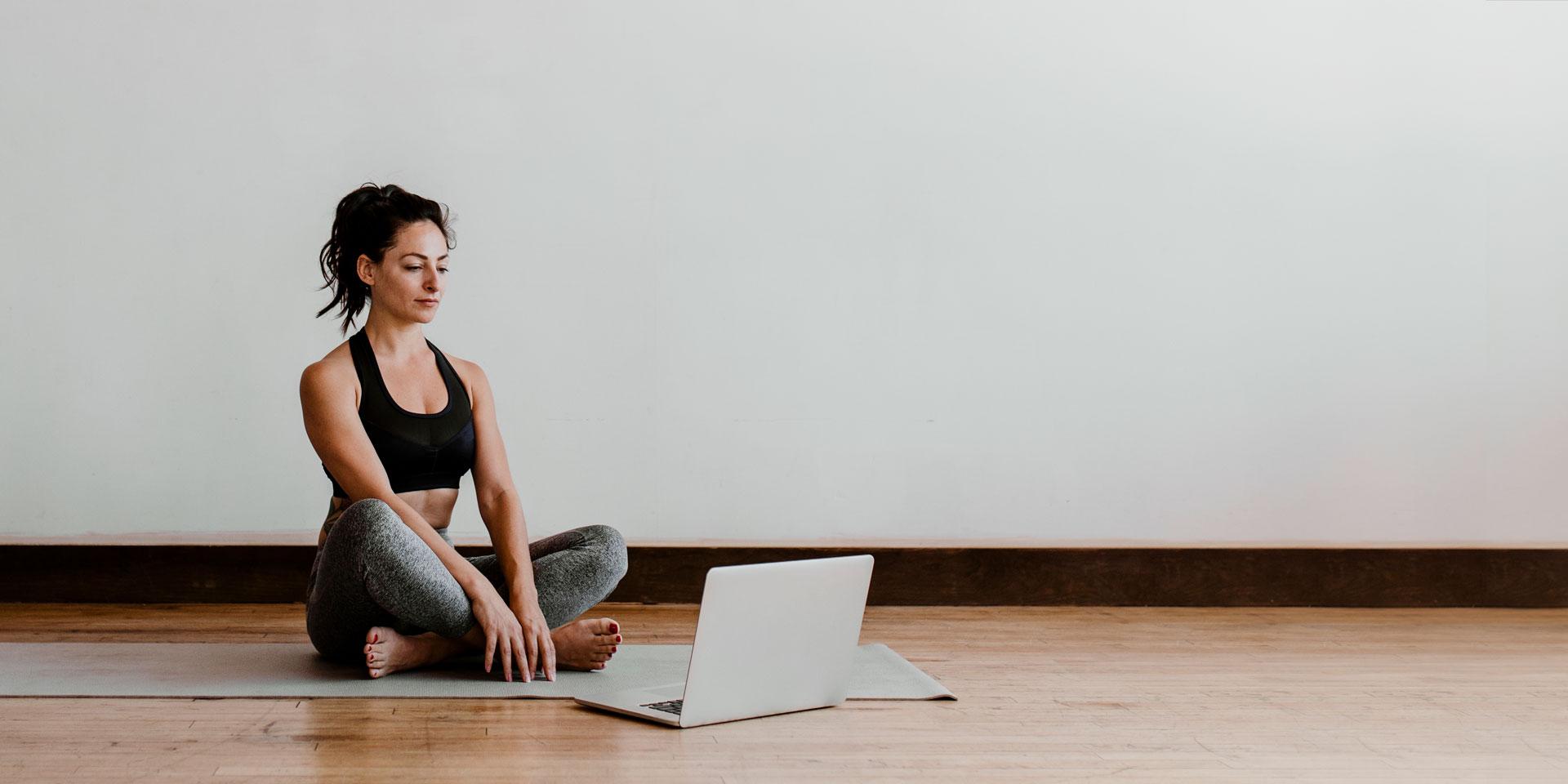 active-woman-learning-yoga-online-via-laptop